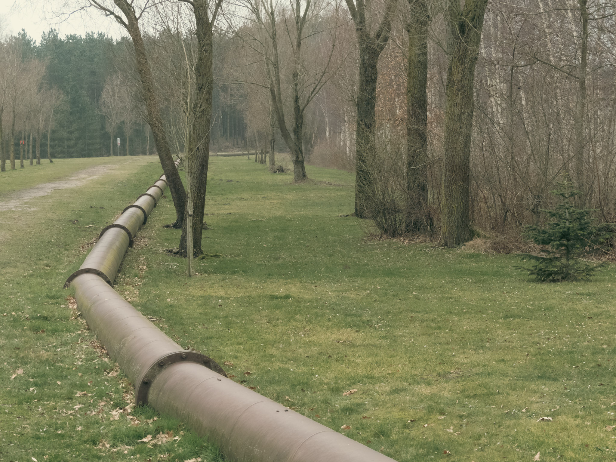 Half bovengrondse pijpleidingen langs een wandelweg