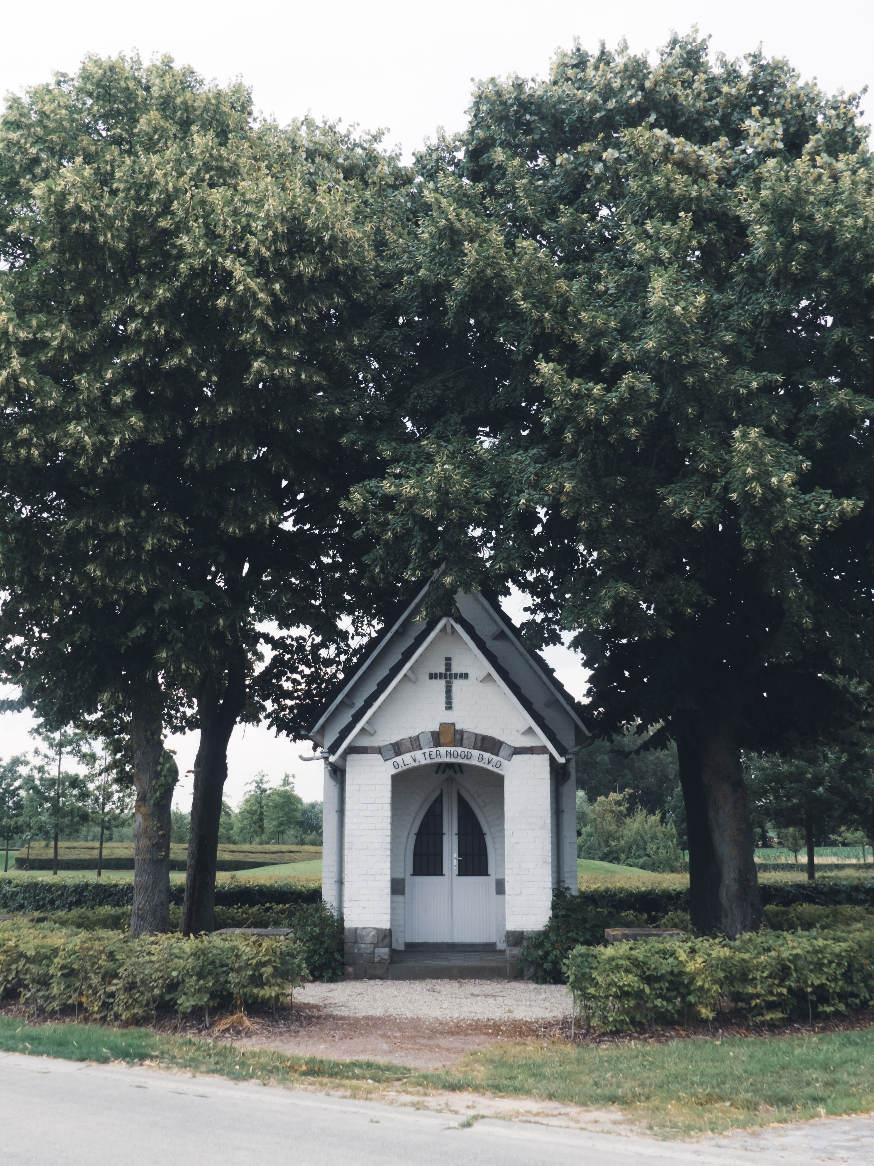 Een wit kappeltje geflankeerd door twee bomen
